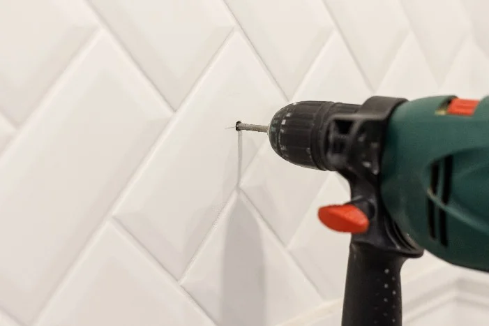 Bohrmaschine bohrt Loch in Fliese